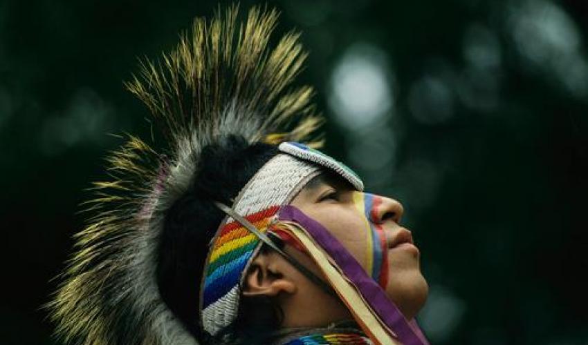 A Stoney Indian brave wears ceremonial headgear during a festival, Banff National Park, Canada